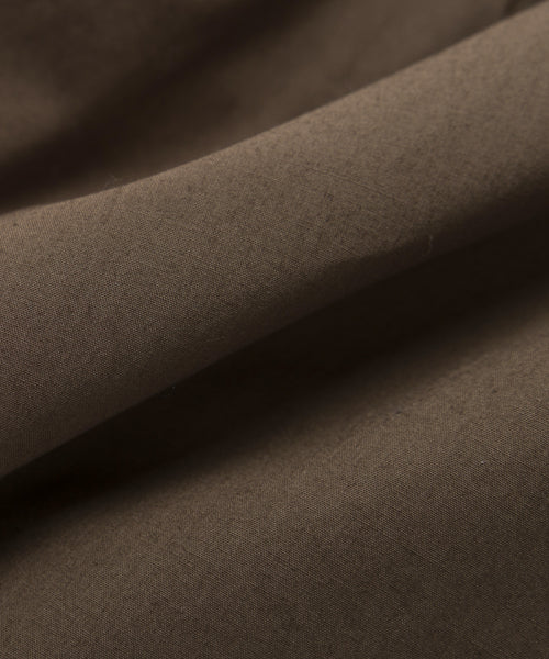 Close-up of smooth, soft brown fabric with visible creases and folds—ideal for the Cove Dress, adding casual flair and comfort.