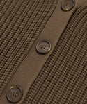 Close-up of the Cropped Cotton Cocoon Cardigan in brown, showcasing a vertical row of three round four-hole buttons on a smooth, matching placket.