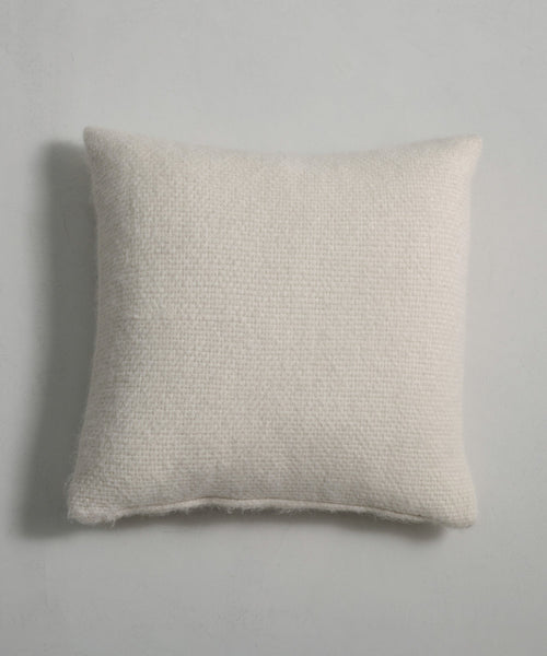 The Alpaca Basketweave Pillow, featuring a rectangular off-white basketweave design and textured surface, rests on a light gray background with a faint shadow cast to the left.