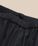 Close-up of the Lauren Skirt’s black waistband with gathered fabric and an inner black tag, set against a beige background.