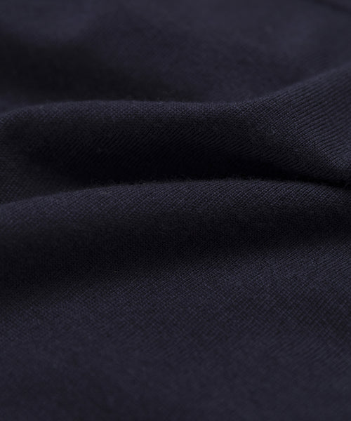 Close-up of the Merino Tank’s dark navy blue merino wool fabric, showing its soft texture, gentle folds, and smooth, slightly fuzzy surface.