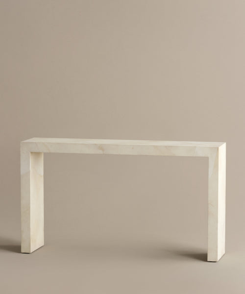 The Napa Console Table features a minimalist rectangular design with clean lines, crafted from smooth, light beige stone and displayed against a plain beige background.