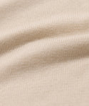 Close-up of the Simone V-Neck in beige, featuring a detailed cotton merino knit with visible texture and soft, wavy folds. Even stitches highlight the luxury quality of this fine layer.