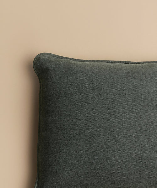 A close-up of the Adler Lumbar Pillow in dark gray linen blend, showcasing its soft, textured fabric against a light beige background.