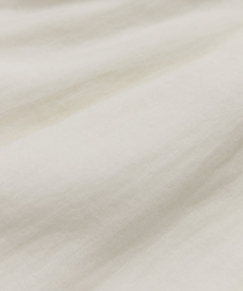 Close-up of the Annabel Skirt shows its white linen fabric with subtle wrinkles, visible threads, and gentle folds for a soft, smooth texture—ideal for achieving a vintage-inspired spring and summer look.