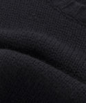 Close-up of the Cashmere Amelia Crewneck, highlighting its textured black cashmere, visible stitching, and soft folds in the luxurious knit fabric.