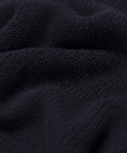 Close-up of the Cashmere Amelia Crewneck’s black chunky knit fabric, showing its ribbed texture and soft, wavy folds—ideal for an oversized sweater look.