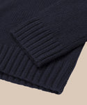Close-up of the Cashmere Amelia Crewnecks navy blue sleeve and hem, highlighting its chunky ribbed knit and fine stitching, laid flat on a light beige background.