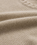 Close-up of the Cashmere Amelia Crewneck in beige, featuring a lightweight chunky knit with a textured pattern and ribbed neckline. The soft fabric and intricate weave create a cozy, elevated look.