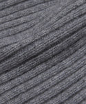 Close-up of the Cashmere Beanie's gray, ribbed knit fabric shows a soft, textured surface with parallel ridges, ideal for lightweight wear.