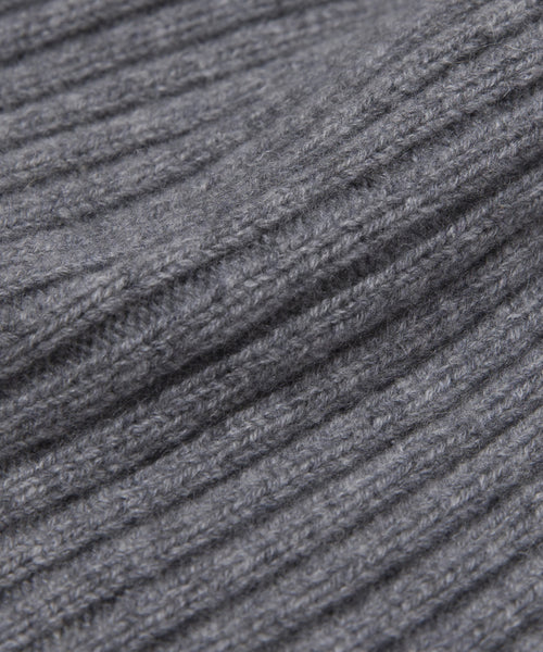 Close-up of the Cashmere Beanie's gray, ribbed knit fabric shows a soft, textured surface with parallel ridges, ideal for lightweight wear.