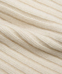 Close-up of a soft, cream-colored ribbed knit fabric from the Cashmere Beanie, showcasing its ivory hue, textured surface, and parallel ridges.