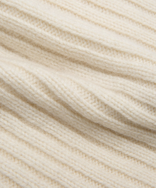 Close-up of a soft, cream-colored ribbed knit fabric from the Cashmere Beanie, showcasing its ivory hue, textured surface, and parallel ridges.
