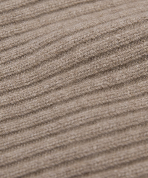 Close-up of the Cashmere Beanie's beige ribbed knit fabric, highlighting its soft wool fibers—ideal for a lightweight beanie with a relaxed fit.