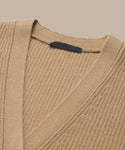 Close-up of the Cashmere Cocoon Cardigan in beige ribbed knit with a V-neckline and a dark label inside the collar, displayed on a neutral background.