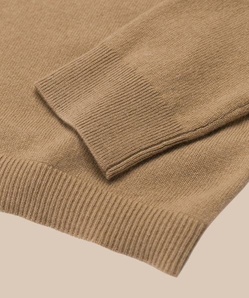 Close-up of the ribbed cuff and hem of the Flynn Cashmere Sweater in light brown, laid flat on a neutral background.