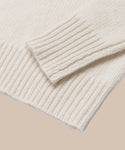 Close-up of the ribbed cuffs and hem on the ivory Cashmere Kate V-Neck sweater, shown against a beige background.
