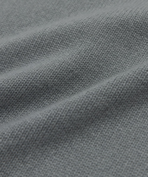 Close-up of the gray textured fabric from the Cashmere Oversized Crewneck, showcasing its visible weave pattern and soft folds that create gentle shadows.