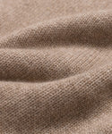 Close-up of a soft, beige knitted fabric with visible texture and gentle folds, highlighting the fine weave and cozy feel—ideal for the Cashmere Oversized Crewneck.