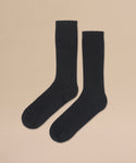 A pair of Cashmere Socks in black, laid flat side by side on a beige background—an elegant gift for any occasion.