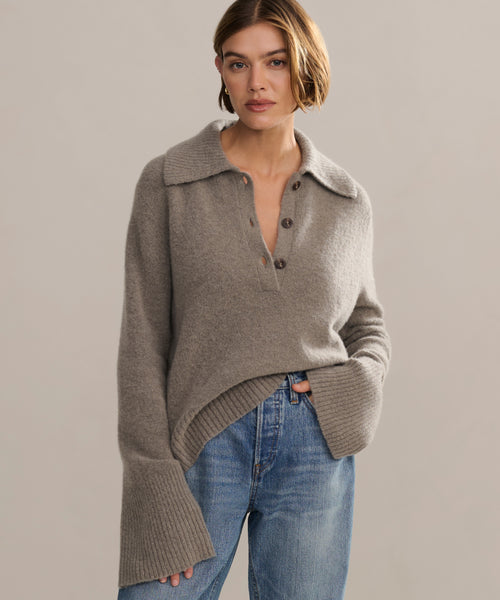Model wearing sweater with ribbed, exaggerated collar, buttoned neck and bell sleeves.