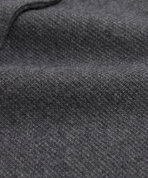 Close-up of the Cooper Cardigan’s dark grey wool fabric, highlighting its soft, textured surface, fine weave pattern, gentle folds, and smooth, slightly fuzzy appearance.