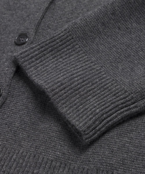 A close-up of a Cooper Cardigan sleeve in dark grey, highlighting the ribbed cuff, part of the body, and visible black buttons.