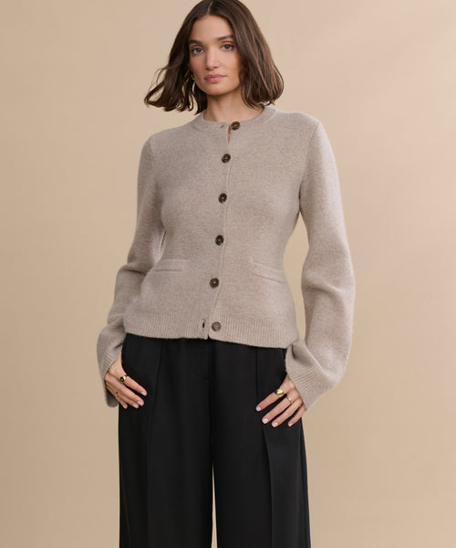 A woman poses for a picture in the Cooper Cardigan, highlighting its structured silhouette.