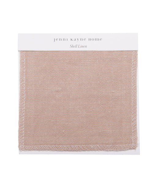 A Fabric Swatch Shell Linen shows a square piece of light pinkish-beige linen with stitched edges, attached to a white card—ideal for accenting the Cove Bed.