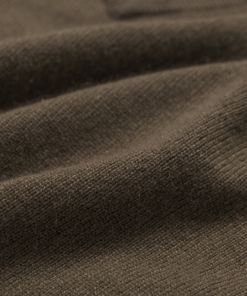 Close-up of the Flynn Cashmere Sweater in brown, showcasing its relaxed fit knit fabric, visible texture, and soft folds—highlighting the weave and subtle fibers for a cozy feel.