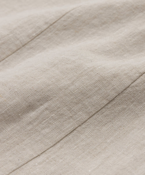 Close-up of the Kinney Skirts beige linen fabric highlights its natural texture, visible fibers, and diagonal seams, making this lightweight skirt soft and ideal for summer wear.