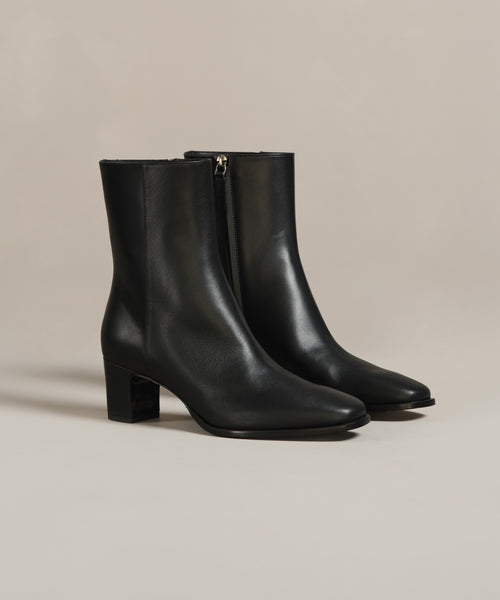The Leather Bobby Boot is a pair of black Italian leather boots with mid-height block heels and side zippers, shown against a neutral background.