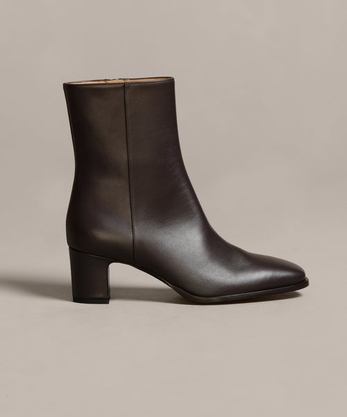 The Leather Bobby Boot, shown in dark brown with a mid-height block heel, side zipper, and smooth finish, is displayed against a neutral background—a stylish and versatile womens boot for any occasion.