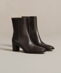 The Leather Bobby Boot is a sleek, dark brown ankle boot for women, featuring a side zipper and block heels. Displayed on a neutral background, it’s an effortlessly versatile choice for any occasion.
