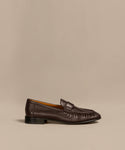 The Leather Dylan Loafer is a dark brown Italian-crafted shoe with a low black heel and moccasin-style stitching, shown in profile against a beige background.