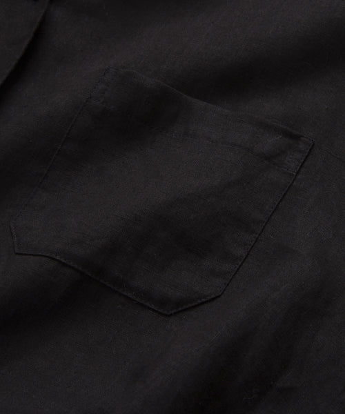 A close-up of the Linen Logan Shirt in black highlights its classic style, with a small chest pocket and simple stitching that emphasize its relaxed design.