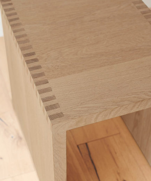 Close-up of the Malibu Side Table corner, showcasing precise dovetail joints and the smooth, light-colored White Oak wood grain, highlighting minimalist design and expert craftsmanship.