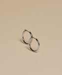 Medium Eloise Hoops are displayed on a smooth, beige surface, with gentle shadows cast beneath them.