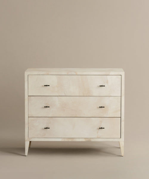 The Napa Dresser has three solid maple drawers with soft-close glides, a light cream finish, and modern metal handles, all showcased against a beige background.
