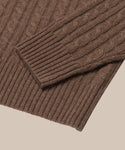 Close-up of the Nell V-Neck Sweater in brown, highlighting its cable knit texture and ribbed sleeve and hem cuffs against a beige background—ideal for fans of relaxed fit sweaters.