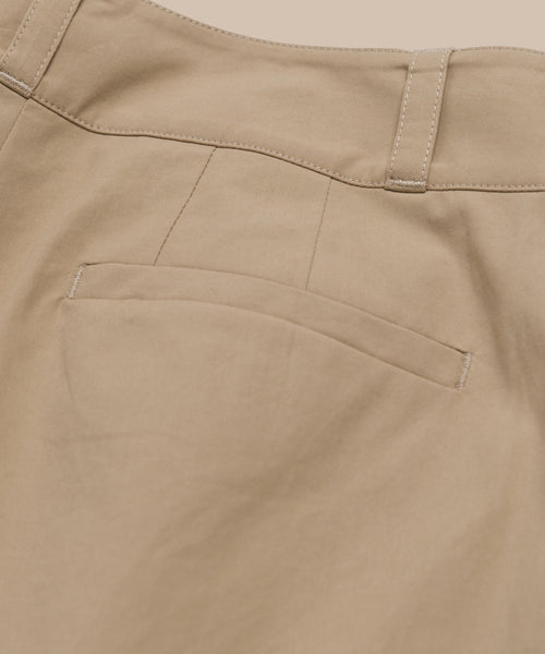 Close-up of the back pocket area of the Newport Trouser, featuring a single welt pocket, belt loop, and visible stitching on smooth beige cotton poplin fabric.