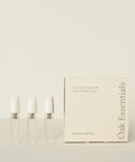 Three small clear perfume vials stand beside a cream-colored box labeled Eau De Parfum Discovery Set, ideal for exploring signature scents, all displayed against a light background.