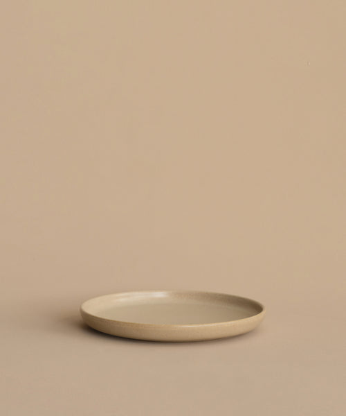 A Pacific Salad Plate, round and beige, rests on a matching surface with a beige background, forming a minimal and neutral scene.