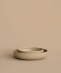 Two round beige Pacific Soup Bowls are nested together on a matching surface with a plain background, highlighting the elegant Pacific Soup Bowl stoneware dinnerware.