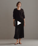 Thumbnail for video: Model walking in-studio wearing Pleated Skirt in Black.