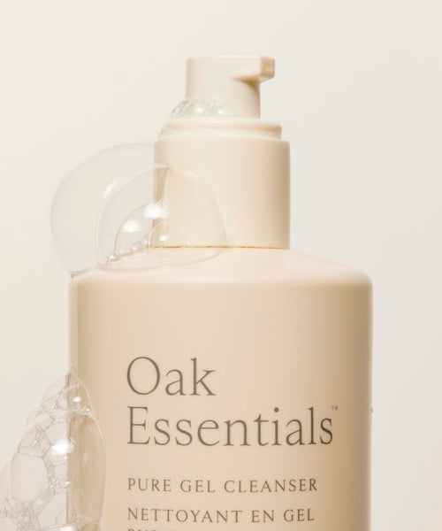 A beige bottle of Pure Gel Cleanser with a pump dispenser sits on a neutral background, featuring minimal text and foam bubbles on the side.