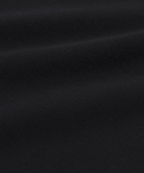 Close-up of the Cotton Rib Tanks black cotton blend fabric, featuring a diagonal weave texture and gentle folds that create subtle shadows and highlights—perfect for layering.
