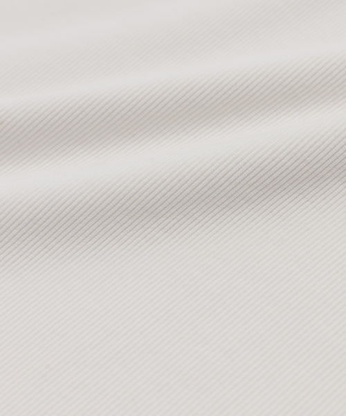 Close-up of the Cotton Rib Tank’s white fabric, showcasing its subtle diagonal ribbed texture, gentle folds, and smooth, clean appearance reminiscent of a heavyweight rib tank.