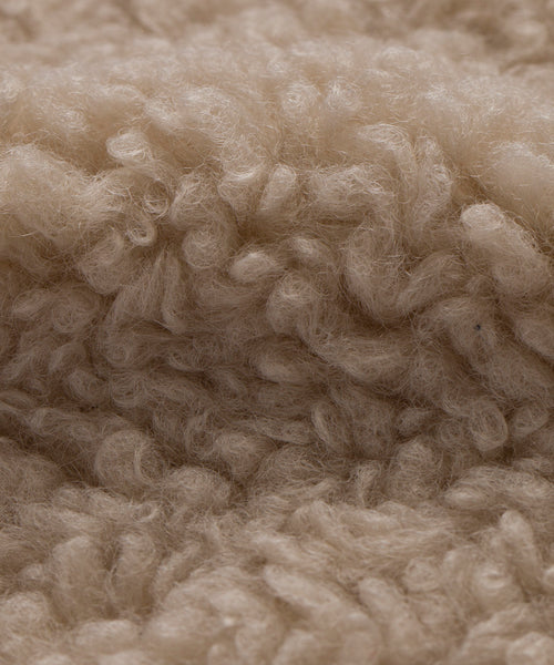 Close-up of light beige, curly, and fluffy Bone Sherpa fibers with a soft, textured look—ideal for the Fabric Swatch Bone Sherpa.