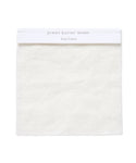 The Fabric Swatch Ivory Linen is a square sample of subtly textured ivory Belgian flax linen, neatly hemmed, with a white label at the top reading jenni kayne home and Ivory Linen in light gray.